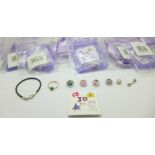 A collection of children's sterling silver jewellery including three rings, a charm bracelet and