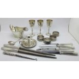 Three small plated goblets with crossed kukri emblem, a plated chamber stick, four napkin rings, a