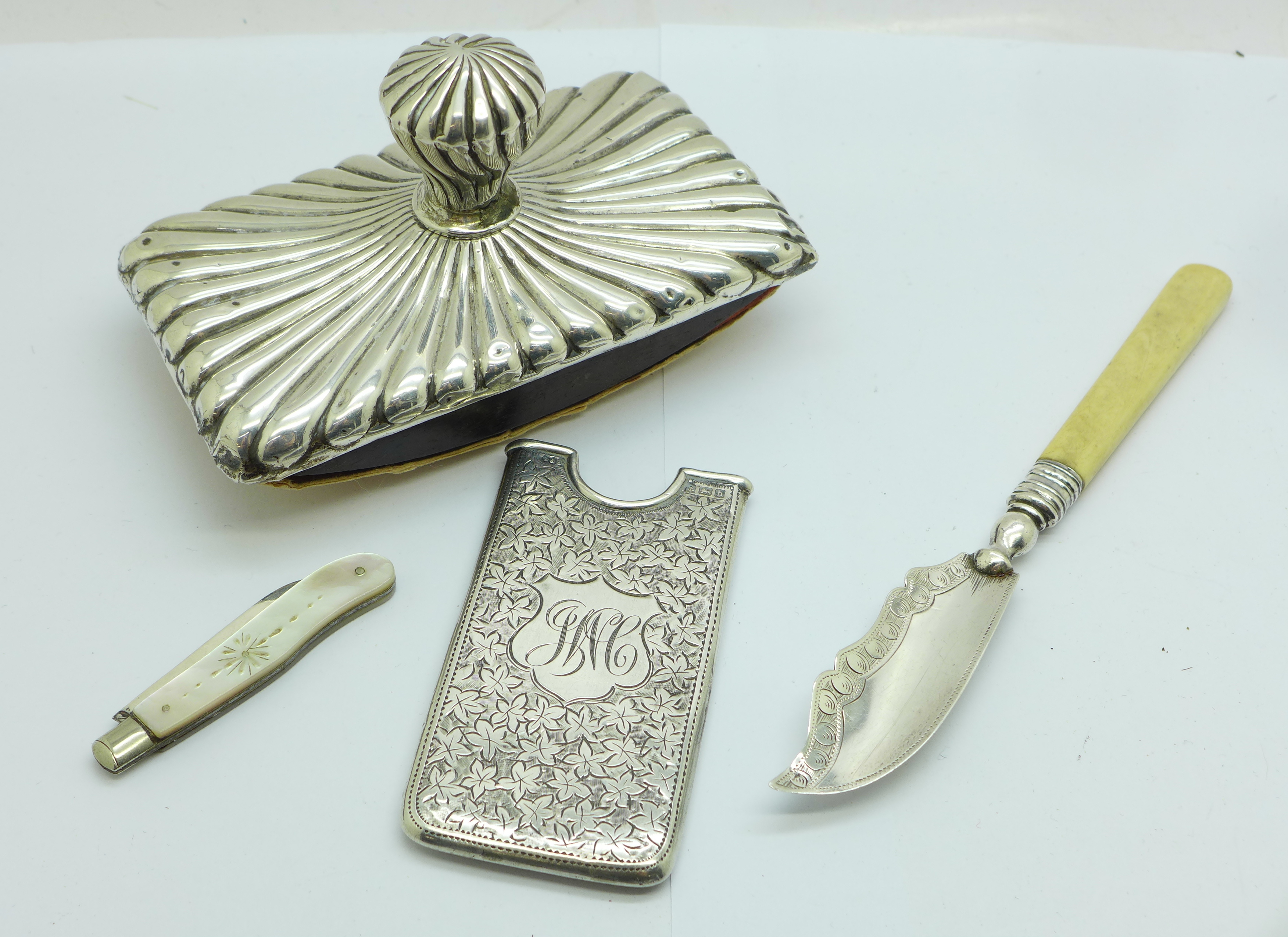 A silver card case, a silver butter knife, a silver and mother of pearl fruit knife and a