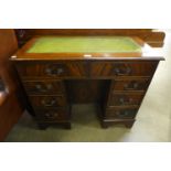 A mahogany and green leather topped kneehole desk