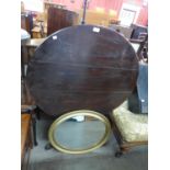 A George III oak circular tilt top tripod table and an oval gilt framed mirror