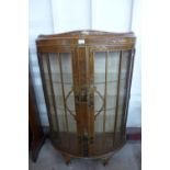 A Japanned walnut bow fronted display cabinet
