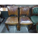 A pair of oak and leather dining chairs
