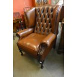 A Chesterfield brown leather wingback armchair