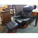 A beech and brown leather swivel reclining armchair and matching stool