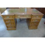 A Victorian oak and green leather topped pedestal desk