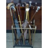 A collection of sixteen walking sticks and umbrellas, three with silver tops, one with 18ct gold