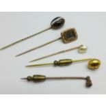 Five stick pins including yellow metal and tigers eye