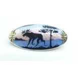 A small silver and enamel brooch, possibly Scandinavian, reindeer winter scene