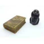 A carved stone figure of a chimpanzee holding a nut and a carved agate Bible