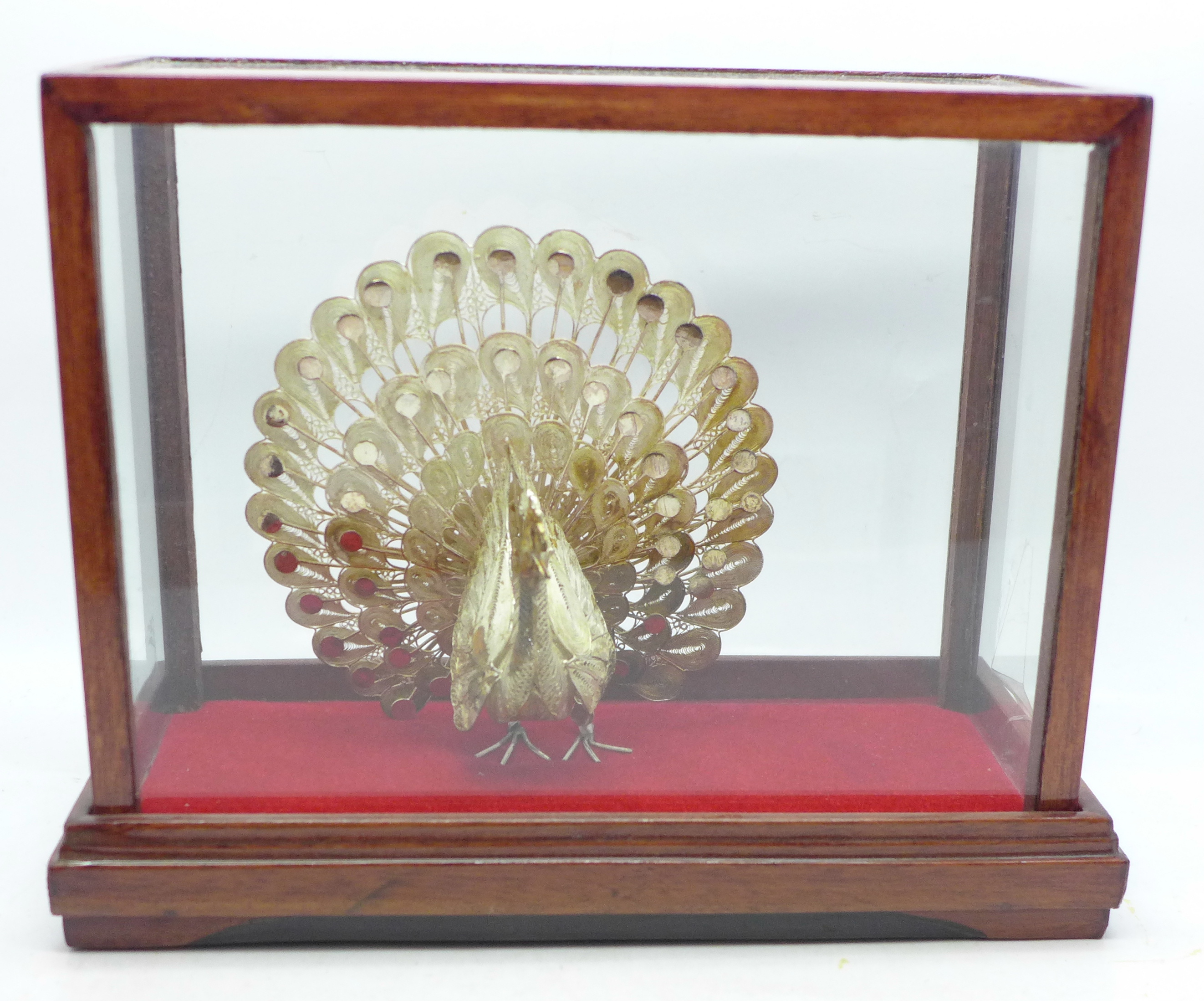 A .925 silver peacock in display case, 12cm