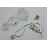 Three Swarovski hedgehogs, a Swarovski necklace and pendant and a pin badge