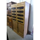 A mid 20th Century oak haberdashery shop cabinet, 172cms h, 94cms w , 48cms d