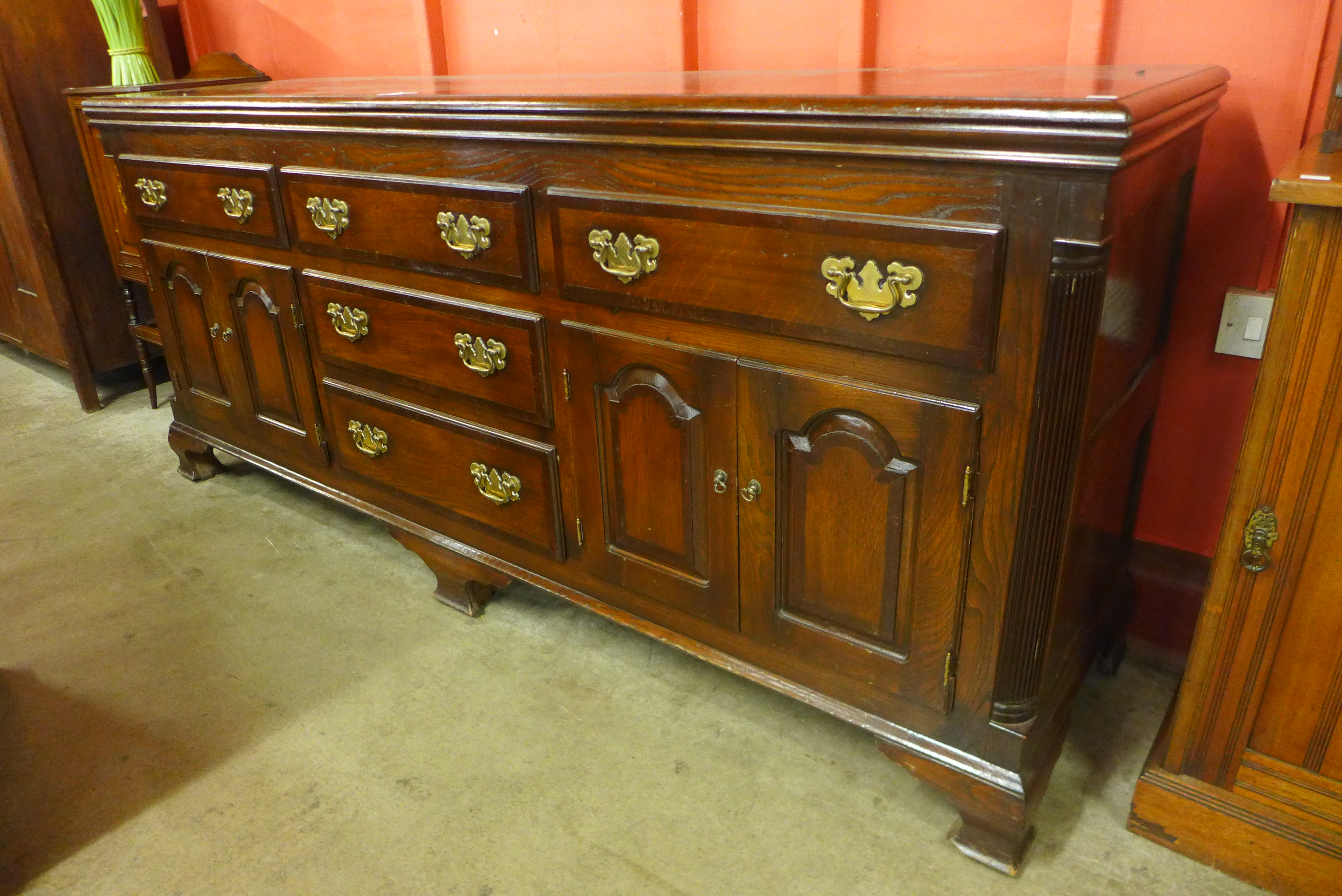 A George III style oak and mahogany crossbanded dresser, 88cms h, 200cms w, 55cms d