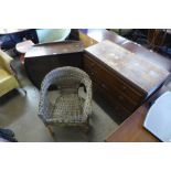 An oak chest of drawers, a small display cabinet and a wicker chair