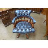 A mahogany and blue leather revolving desk chair
