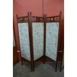 An Arts and Crafts walnut and fabric panelled folding screen