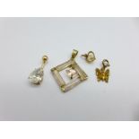 A 9ct gold butterfly charm, two yellow metal set pendants and a stud