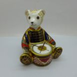 A Royal Crown Derby paperweight, Teddy Bear Drummer, with double M monogram to the base, with gold