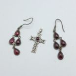 A silver and garnet cross pendant and a pair of silver and garnet earrings