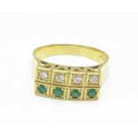 An 18ct gold, eight stone diamond and emerald ring, 3.9g, O