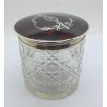 A silver and tortoiseshell topped glass jar