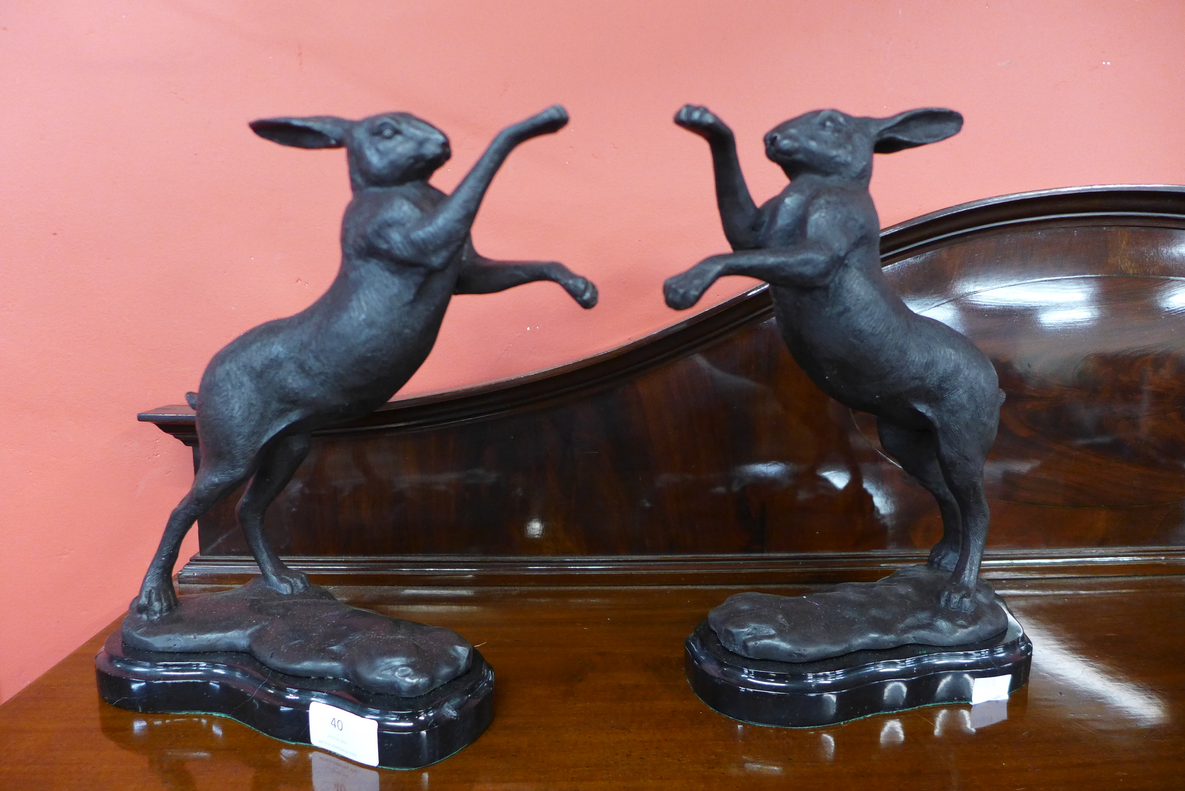 A pair of bronze boxing hares on marble base