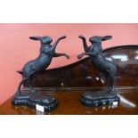 A pair of bronze boxing hares on marble base