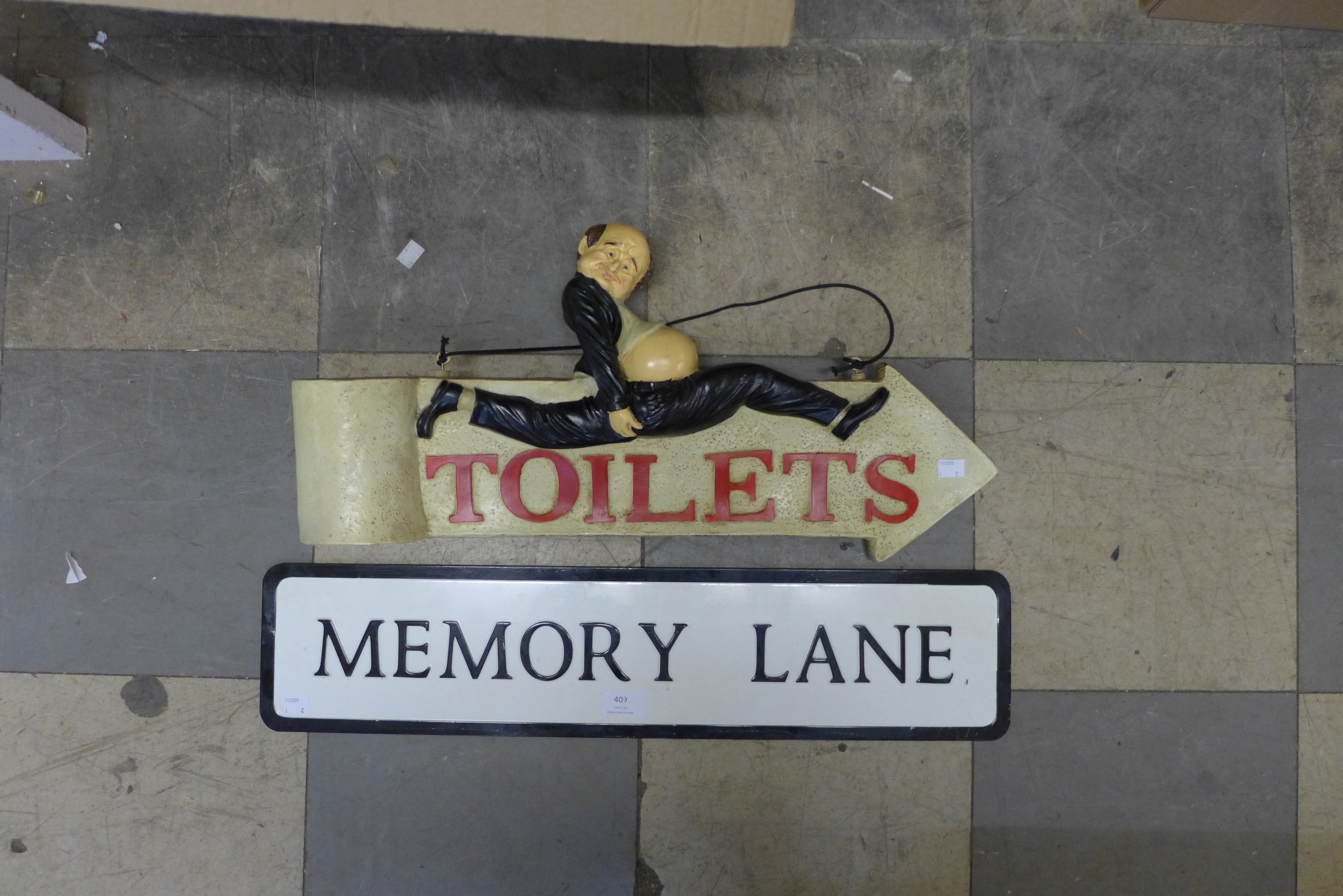 A humorous double sided toilet sign and a tin Memory Lane street sign