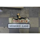 A humorous double sided toilet sign and a tin Memory Lane street sign