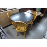 A circular painted dining table and three beech chairs