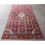 A hand knotted red and black rug, 272cms x 144cms.
