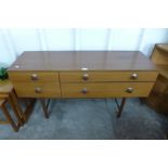 A four drawer small teak sideboard