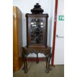 A Victorian carved mahogany corner cabinet on stand