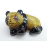 A silver gilt and enamel panda brooch