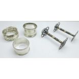 Two silver napkin rings, a plated napkin ring and two knife rests