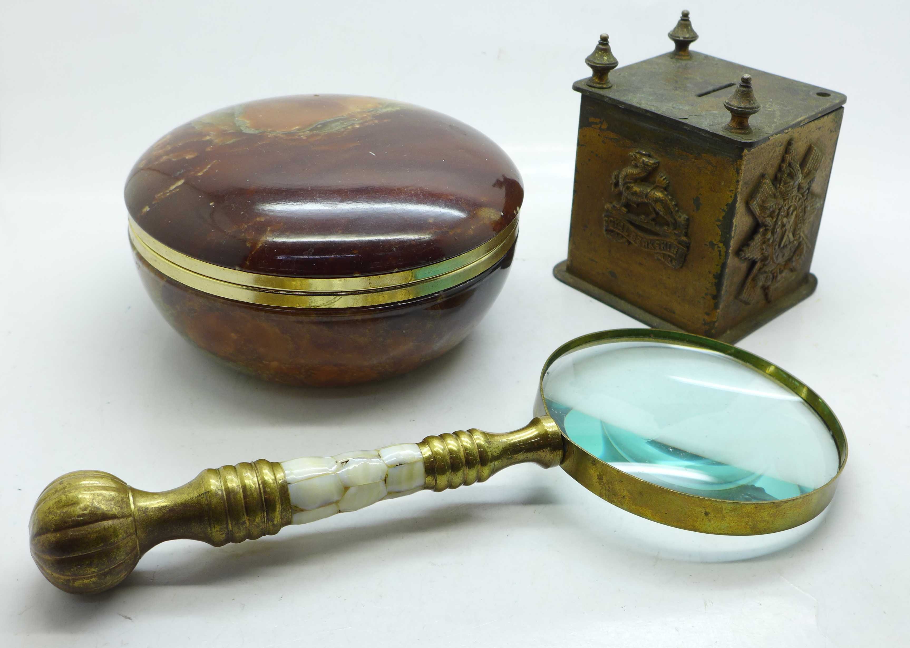 A money box with regimental badges, a magnifying glass with mother of pearl handle and an onyx