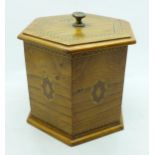 A hexagonal oak tea caddy with lid, marked 1918