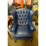 A blue leather wingback armchair