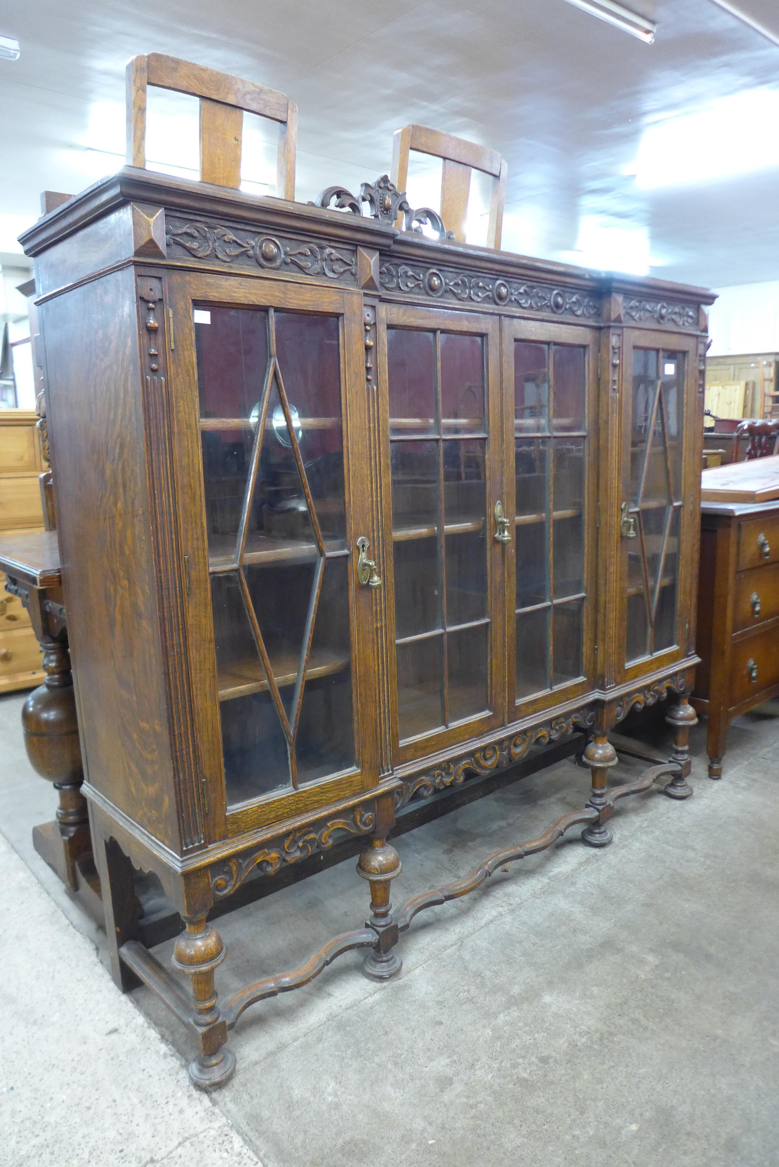 An early 20th Century carved oak four door breakfront bookcase