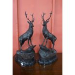 A pair of French style bronze figures of stags, on black marble plinths