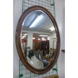 An oval oak framed mirror