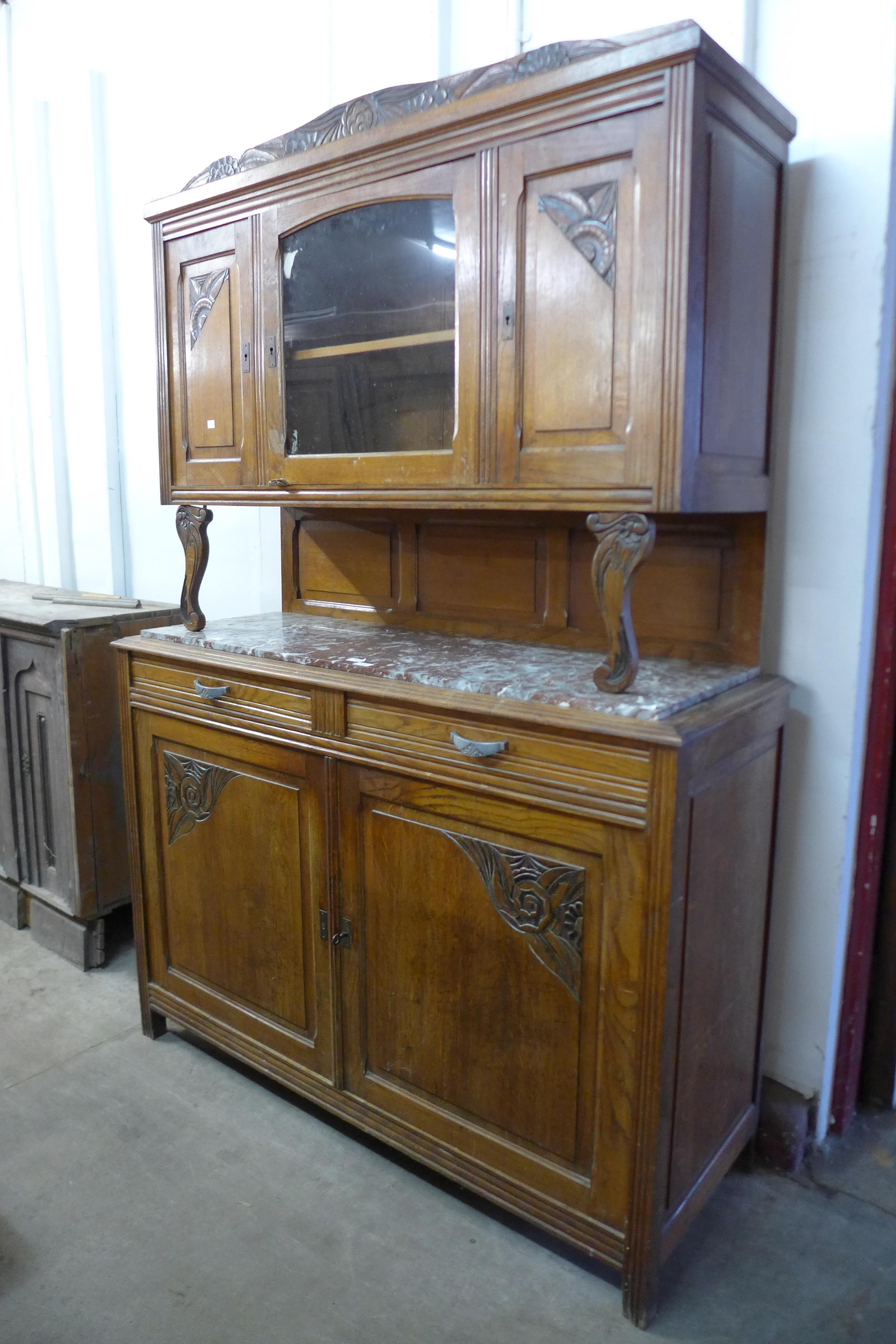 An early 20th century French carved oak and marble topped buffet sideboard