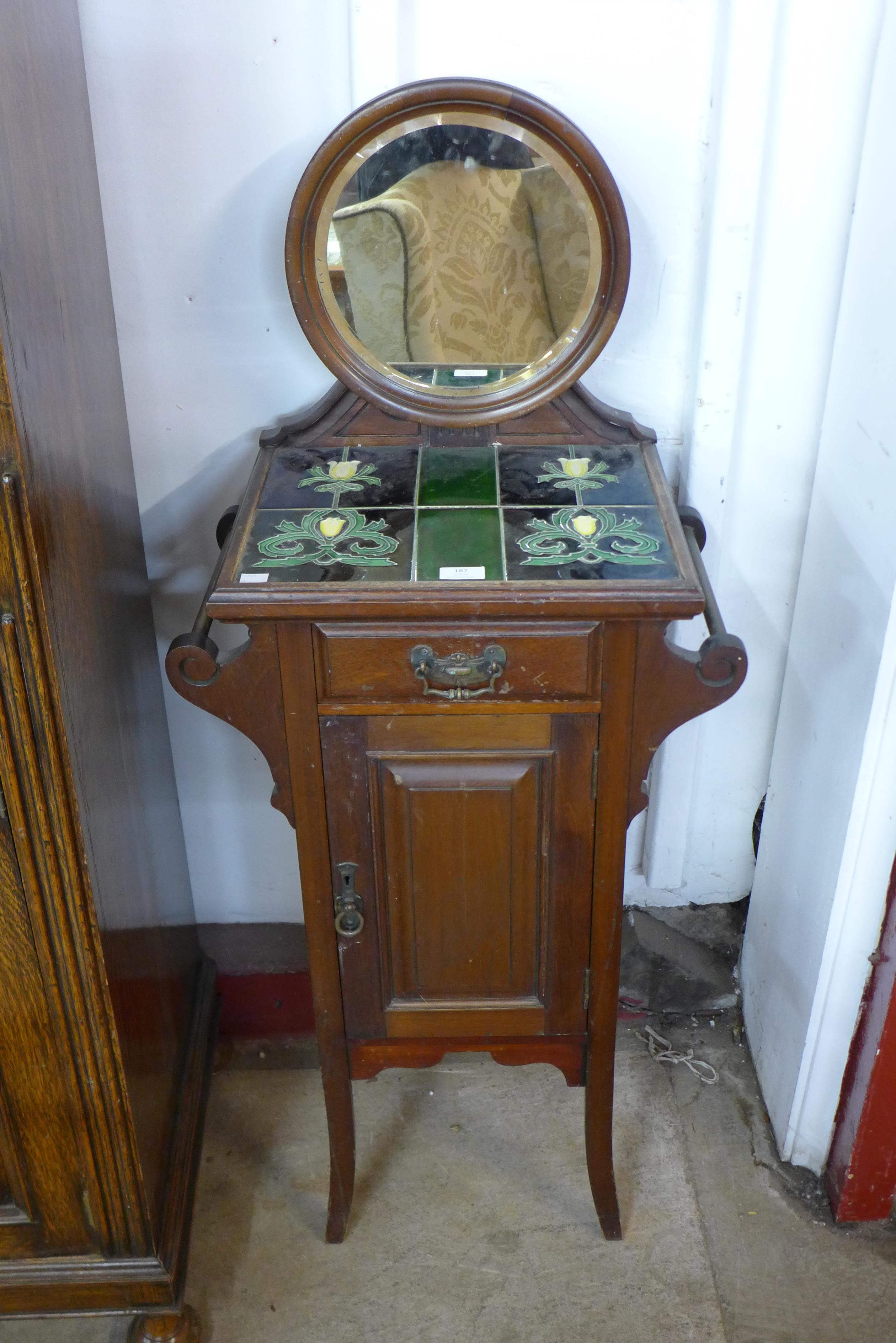 An Art Nouveau mahogany and tiled top cupboard