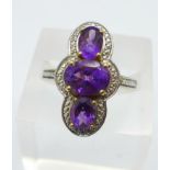 A silver and three stone amethyst dress ring, R