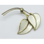 A Norwegian silver gilt and white enamel leaf brooch