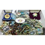 A collection of costume jewellery including brooches and beaded necklaces