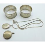 A pair of silver napkin rings and two silver lockets and a chain, 56g