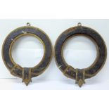 A pair of circular cast plaques in the form of a belt