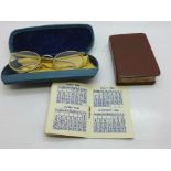 A 1946 calendar, an English to Latin book and a case with children's spectacles, c.1940